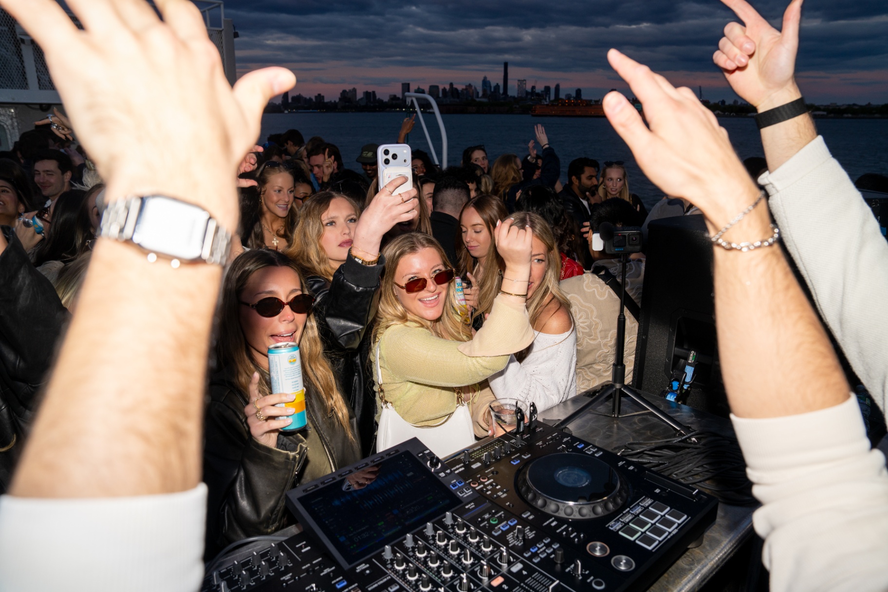 Crowd at the DJ booth with skyline behind